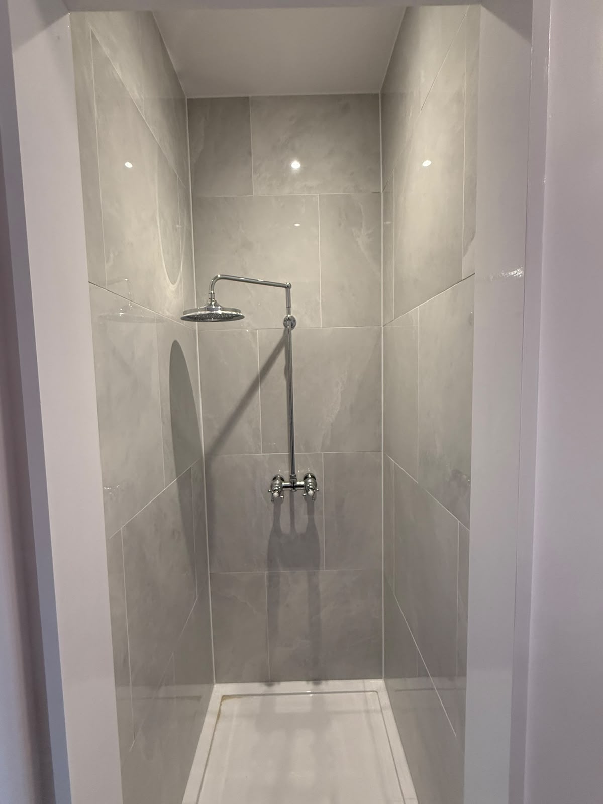 Walk-in shower with tiled walls sealed by Blackline Mastic