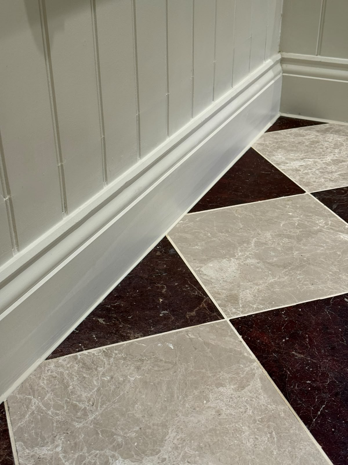 Skirting board and marble floor junction sealed by Blackline Mastic