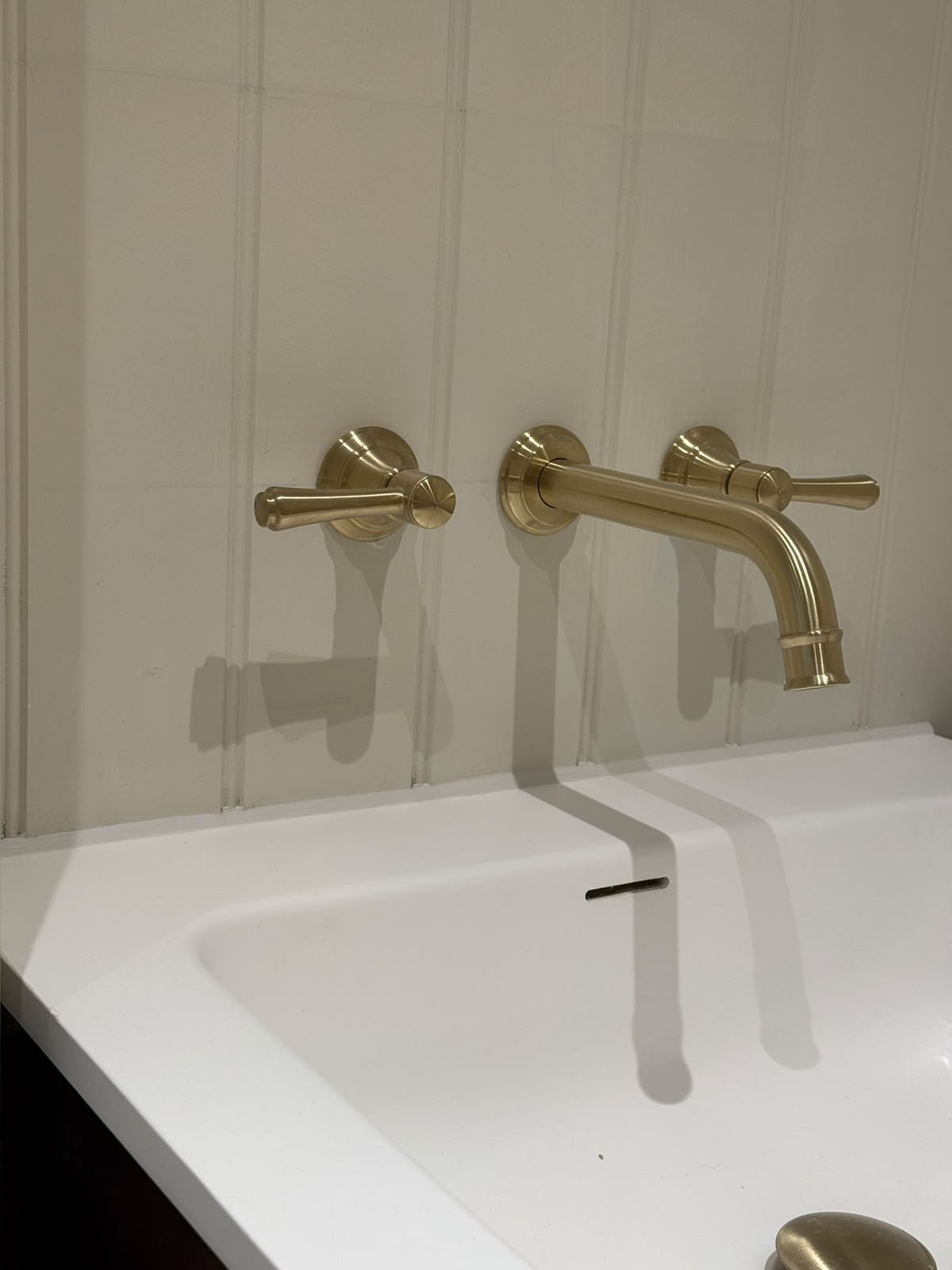Brass wall taps over a basin with a clean sealed edge by Blackline Mastic