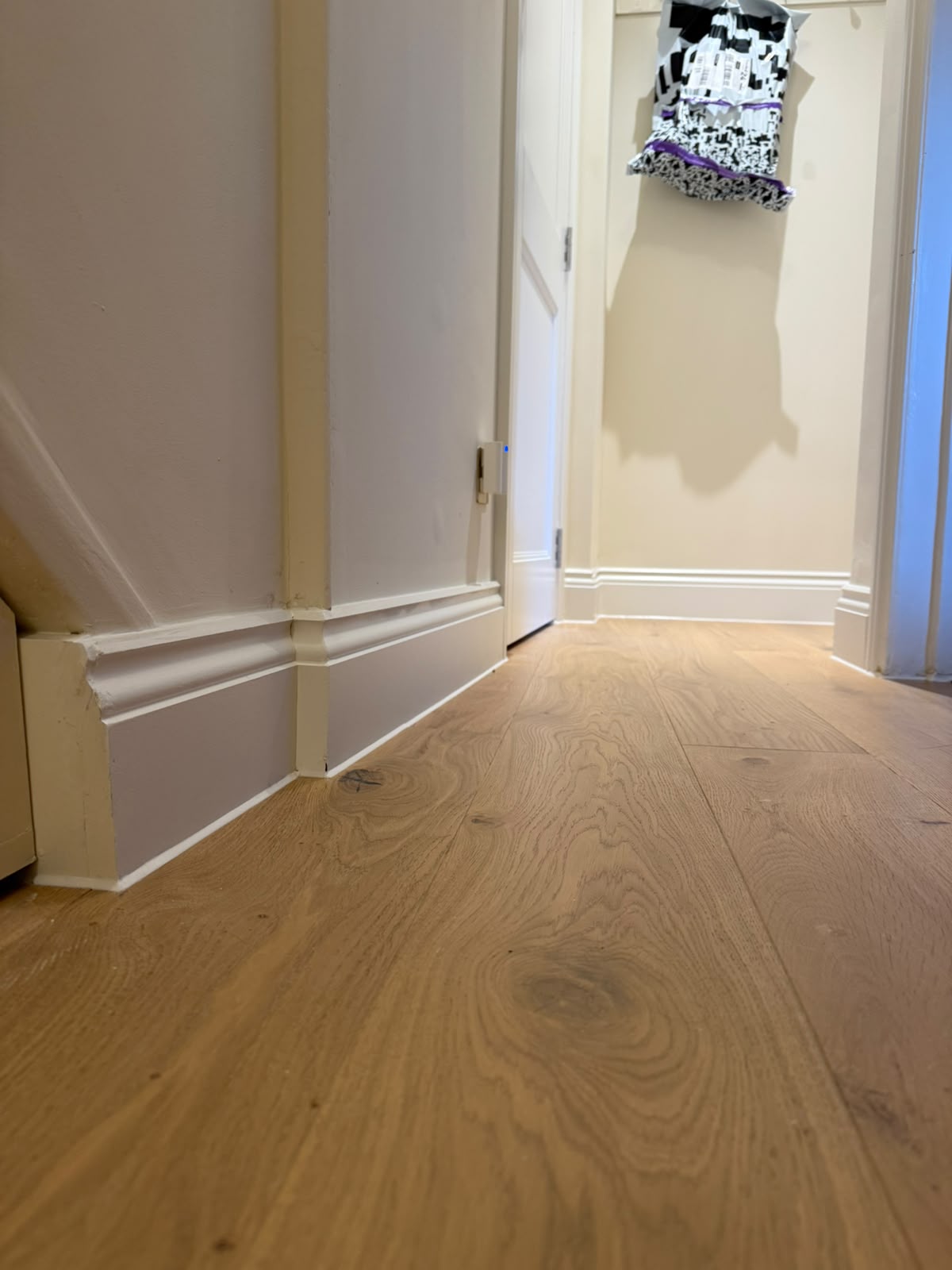 Skirting board and oak floor junction sealed by Blackline Mastic